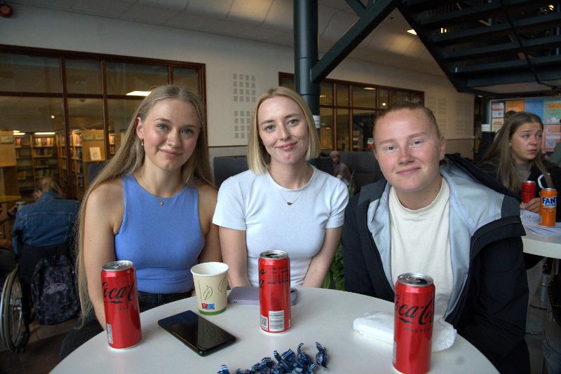 Tre kvinnelige studenter i student-kantine. 